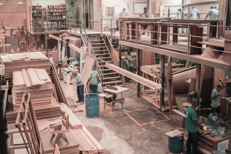 people working with lumber on a manufacturing floor