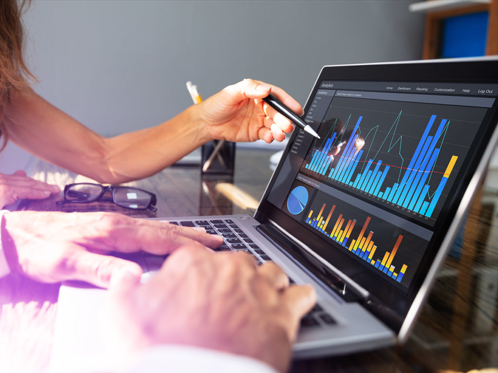 office workers analyzing graph on laptop