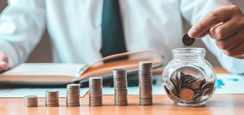 Financial businessman with coins put in a jar, Saving money for future growth and knowing how to manage your spending wisely, Saving money for business growth or long-term profitability.