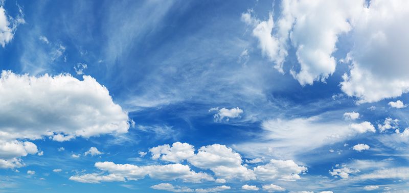 white fluffy clouds on blue sky in summer on sunny day. Beautiful cloudscape background