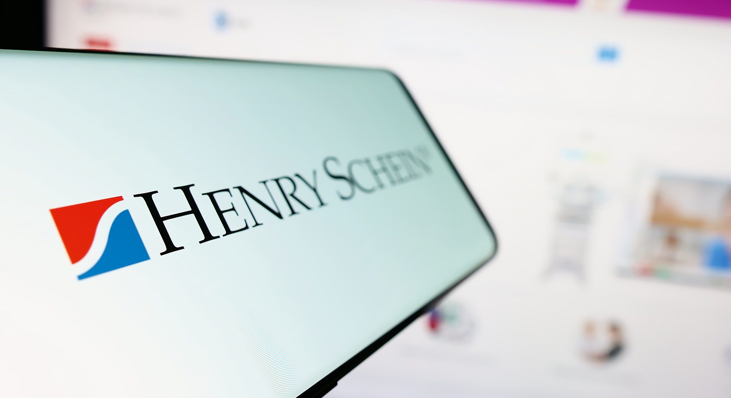 Stuttgart, Germany - 07-02-2023: Cellphone with logo of American healthcare products company Henry Schein Inc. on screen in front of website. Focus on left of phone display.
