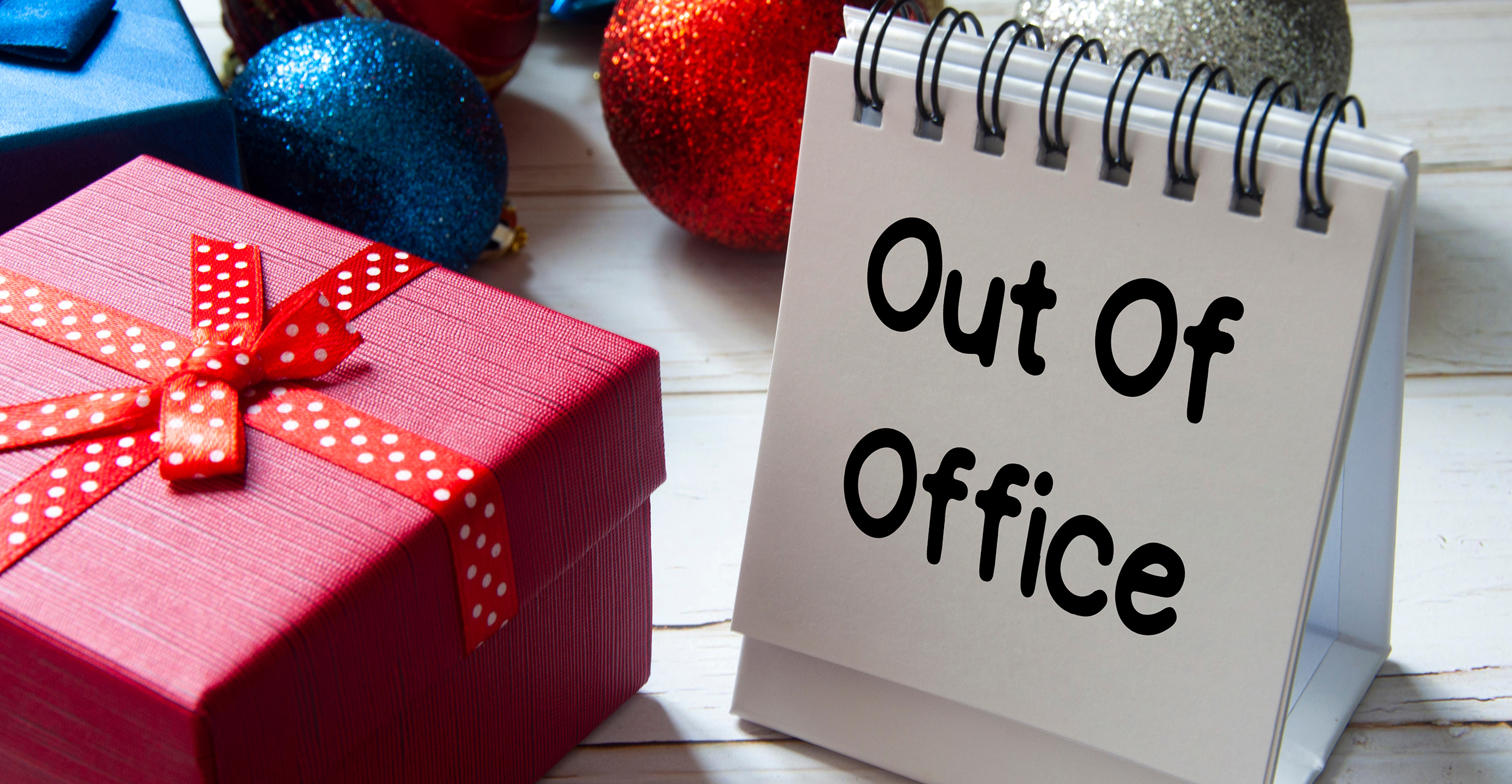Out of office text on notepad with Christmas decoration. Holiday concept.