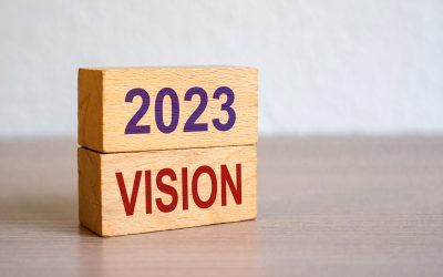 Hand puts blocks with the words 2023 Vision. Concept for business ideas and goals. Strategy development. Planning and action plan. Performance, motivation and company management.