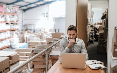 Manager working online while sitting in a warehouse office