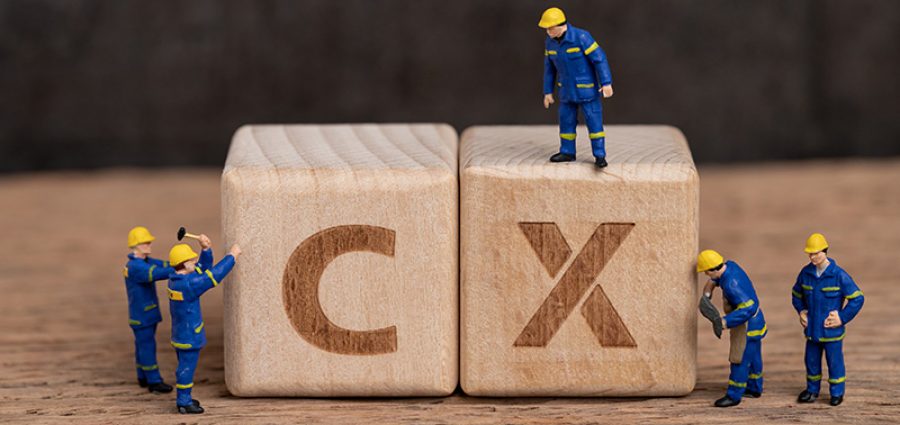 Customer Experience in product and service concept, miniature people workers with blue team uniform building cube wooden block with acronym CX on table with blackboard, user review or feedback.