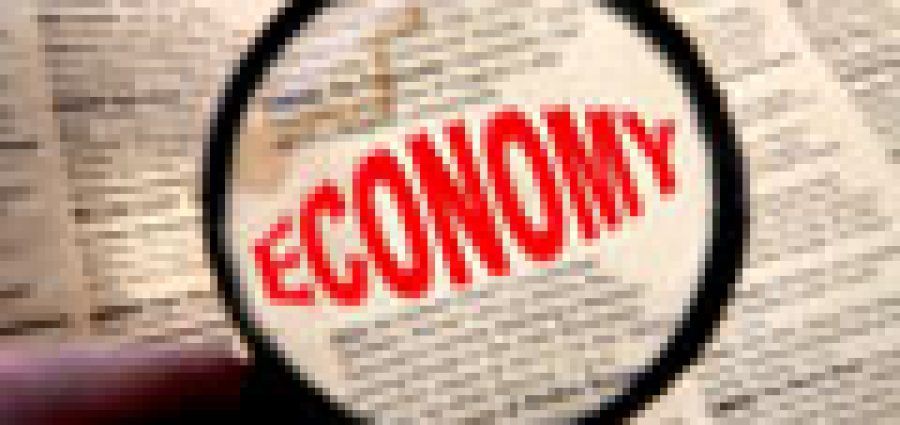 newspaper with the word economy in red enlarged through a magnifying glass.