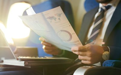 Crop portrait of modern bearded businessman reading documents and working while enjoying flight in first class, copy space