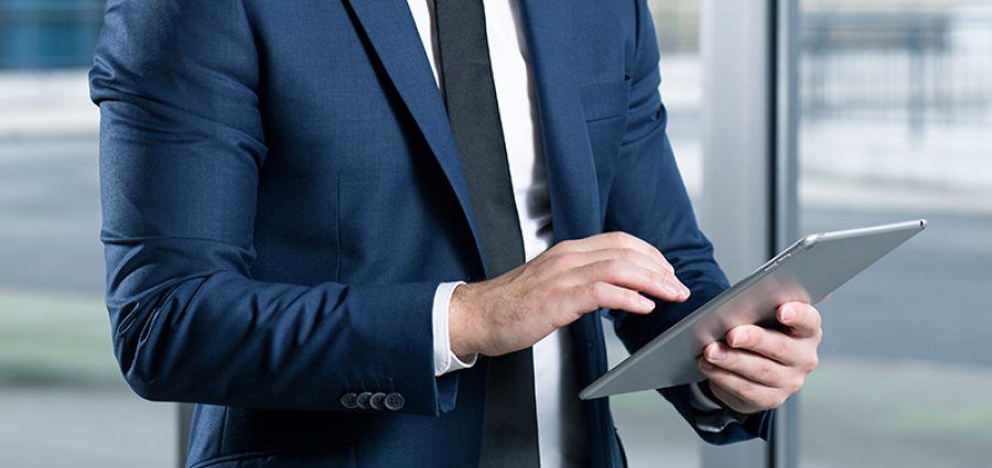Businessman wearing suit and tie using his tablet